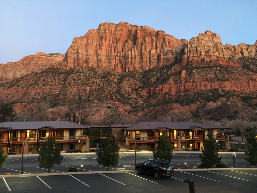 Epic rocks jut out behind a building in Zion National Park. 